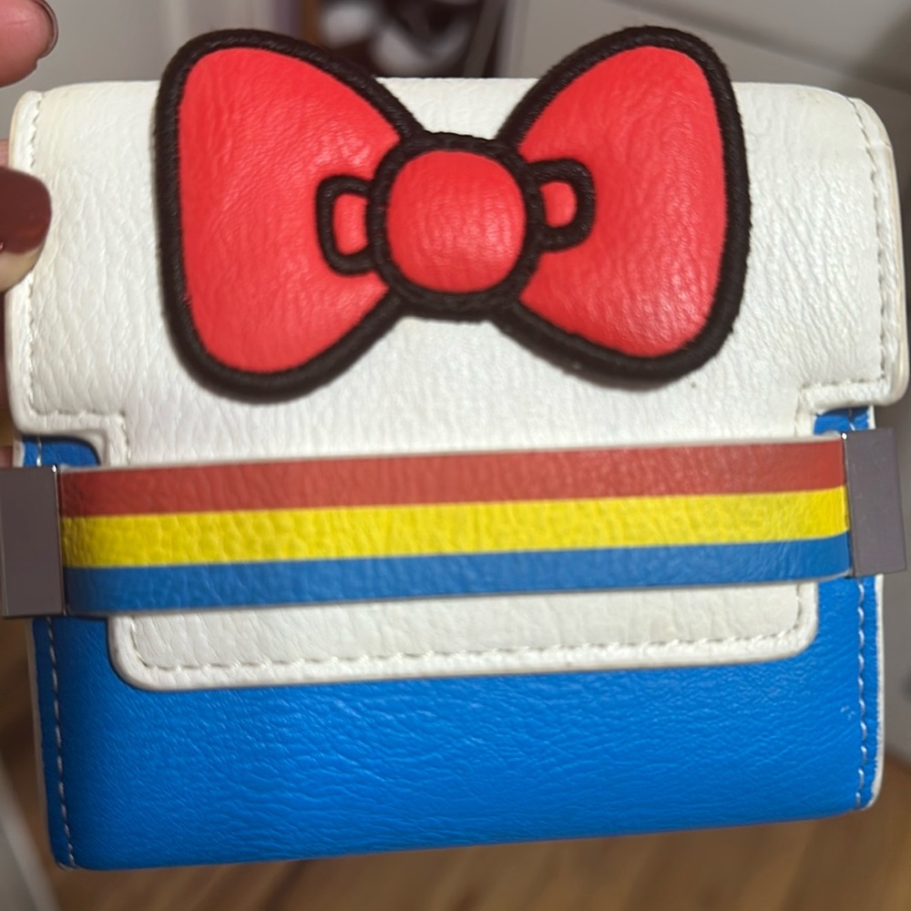 PRE-OWNED. LOUNGEFLY HELLO KITTY 45TH ANNIVERSARY STRIPE BOW BI-FOLD WALLET